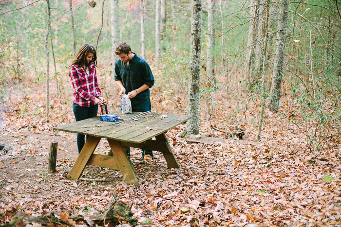 engagement session in the woods, surrounding a fire with smores and flannel in autumn