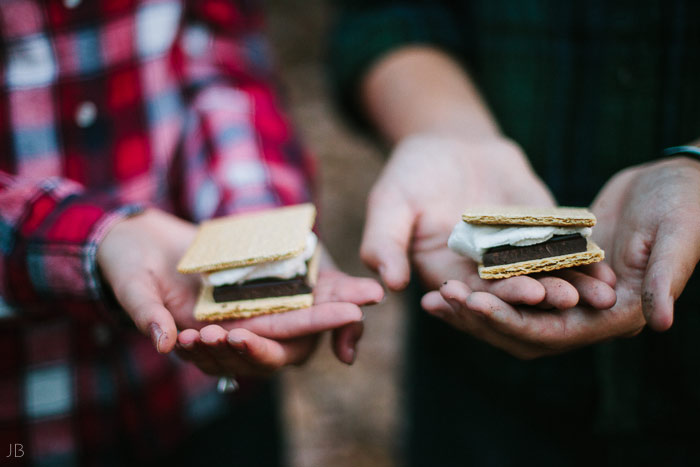 engagement session in the woods, surrounding a fire with smores and flannel in autumn