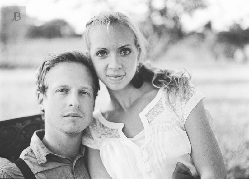 dreamy vintage engagement in an orchard staring at camera black and white film medium format low contrast