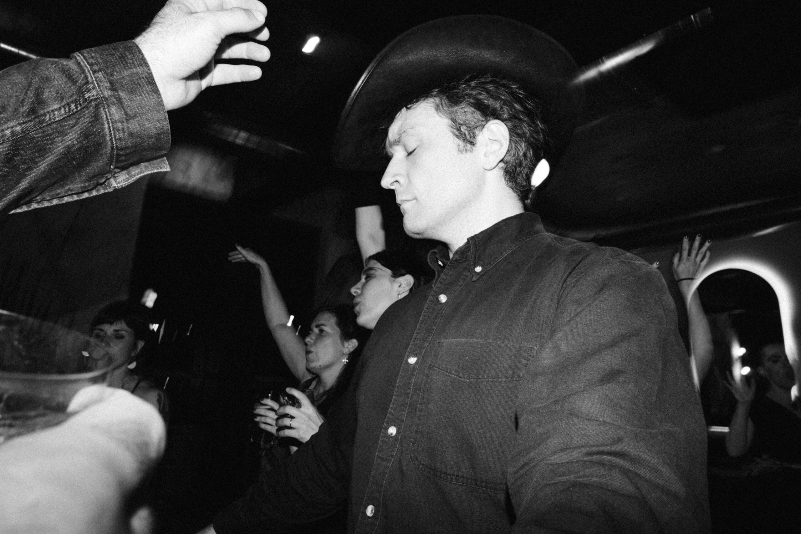 black and white film look wedding photography with direct flash - fujifilm acros film look - man in cowboy hat dancing at wedding reception in philadelphia - philadelphia documentary wedding photographer