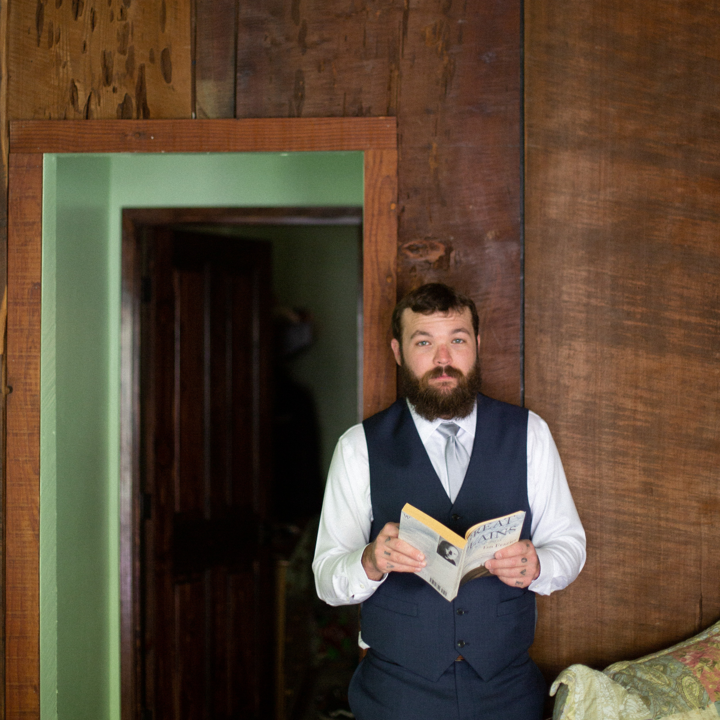 relaxed groom reading a book Great Plains in his room at big sur river inn - big sur california wedding - laid back wedding in big sur california - true to life colors