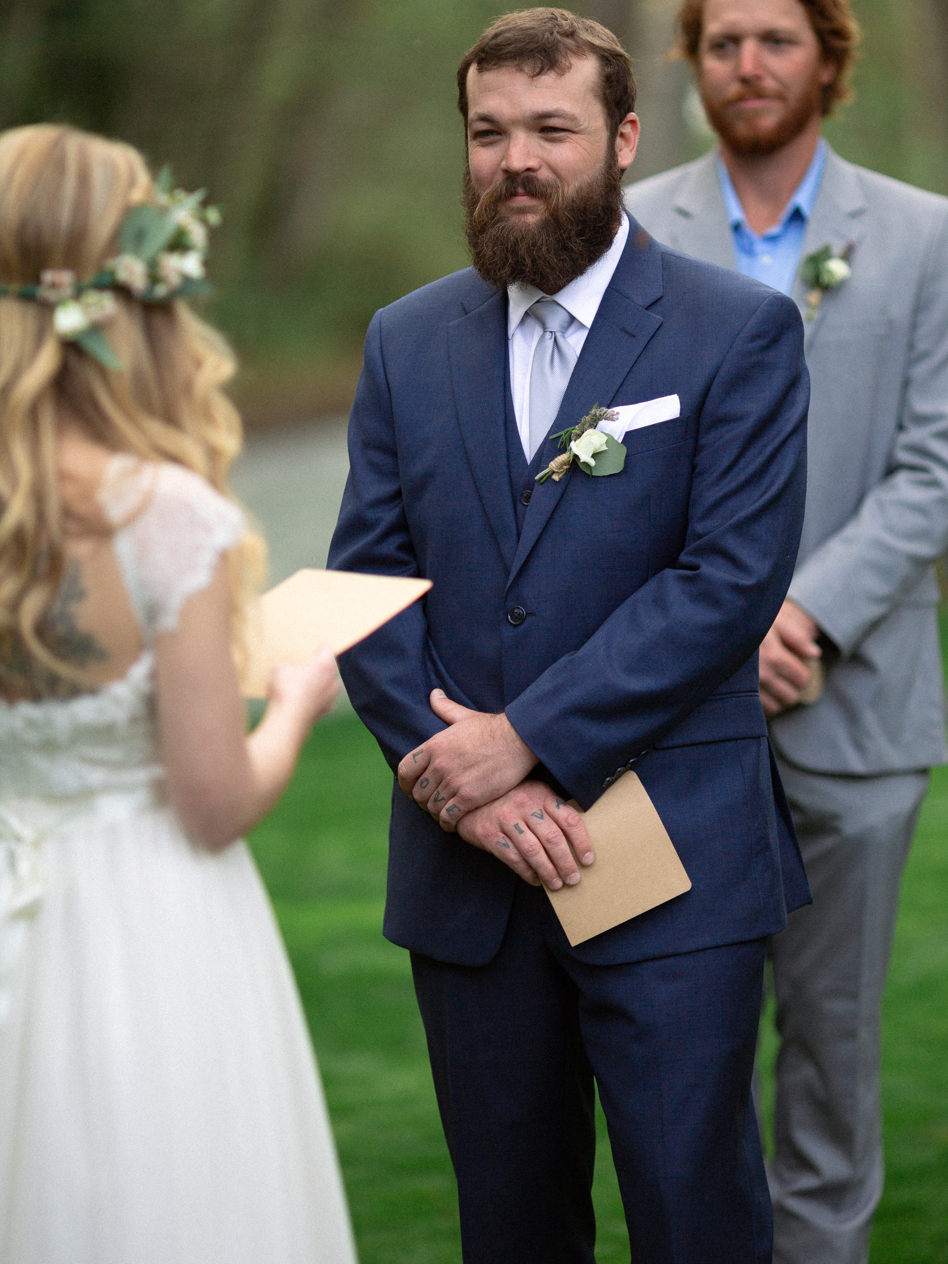 groom smiles as he listens to his bride read the vows  - big sur california wedding - laid back wedding in big sur california - fuji provia film look true to life colors