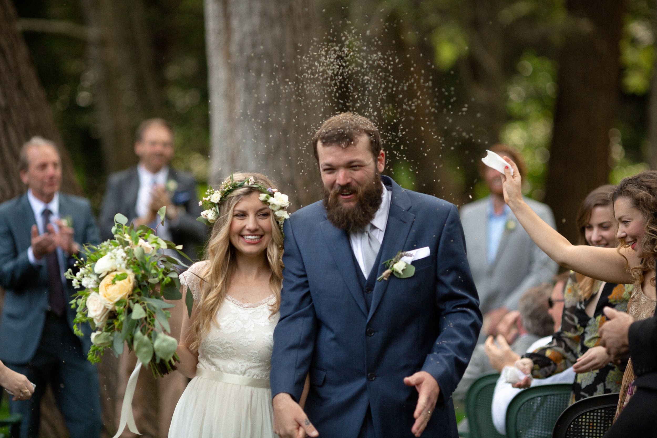 bride and groom exit wedding ceremony in big sur california - people throw birdseed at them  - big sur california wedding - laid back wedding in big sur california - fuji provia film look true to life colors