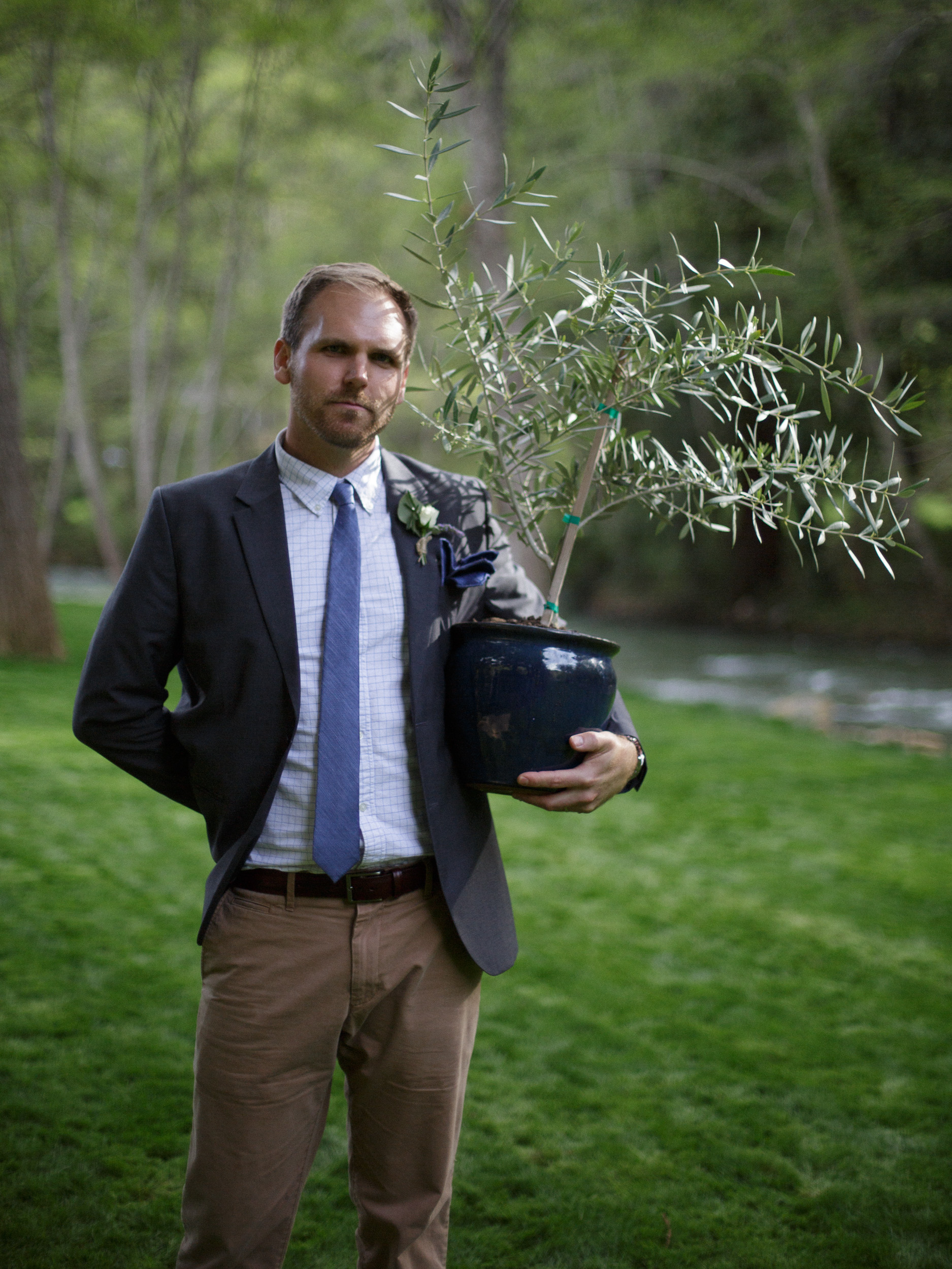 groomsman carries plant on lawn at big sur river inn