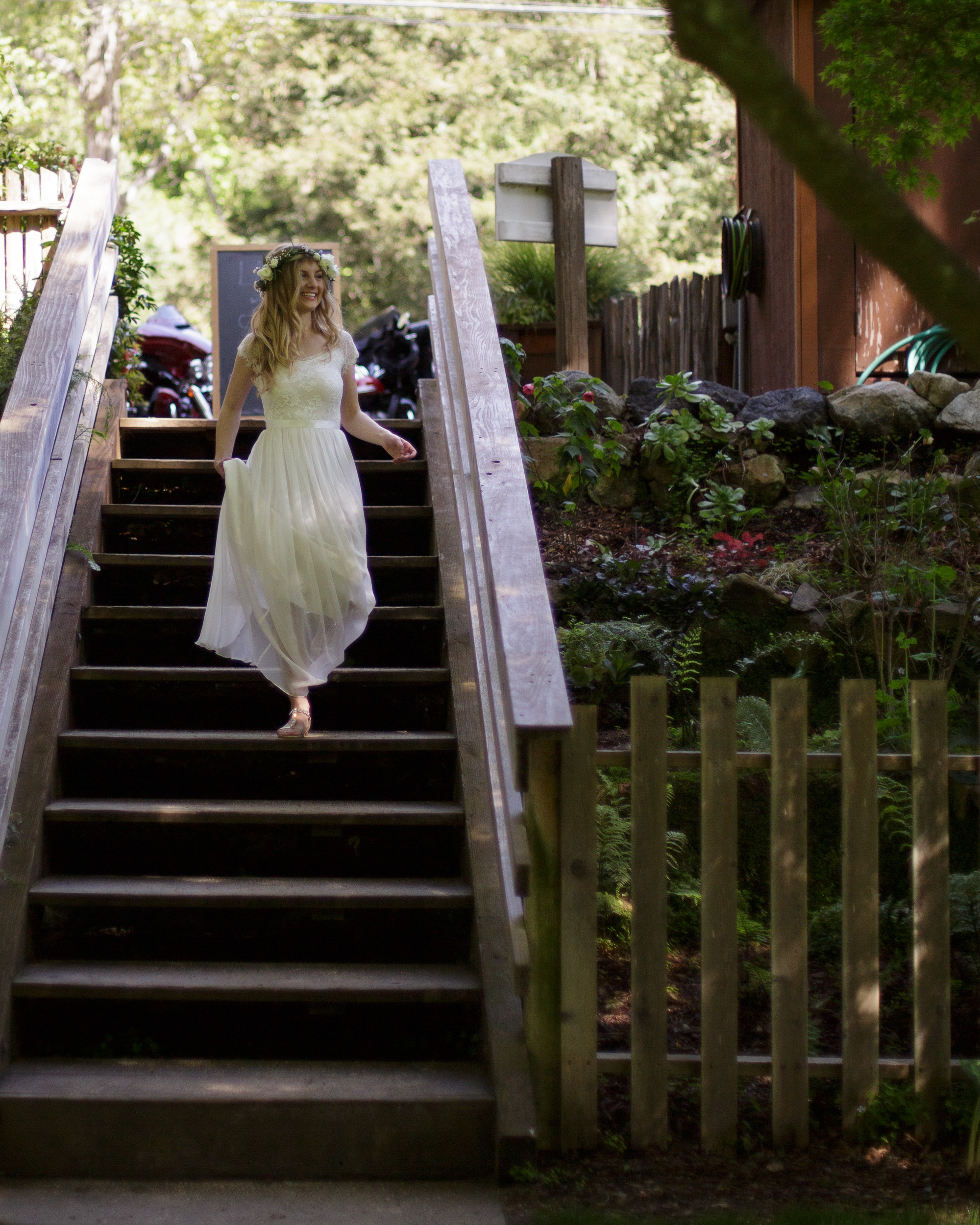 bride descending staircase at big sur bakery - - big sur california wedding - laid back wedding in big sur california - true to life colors