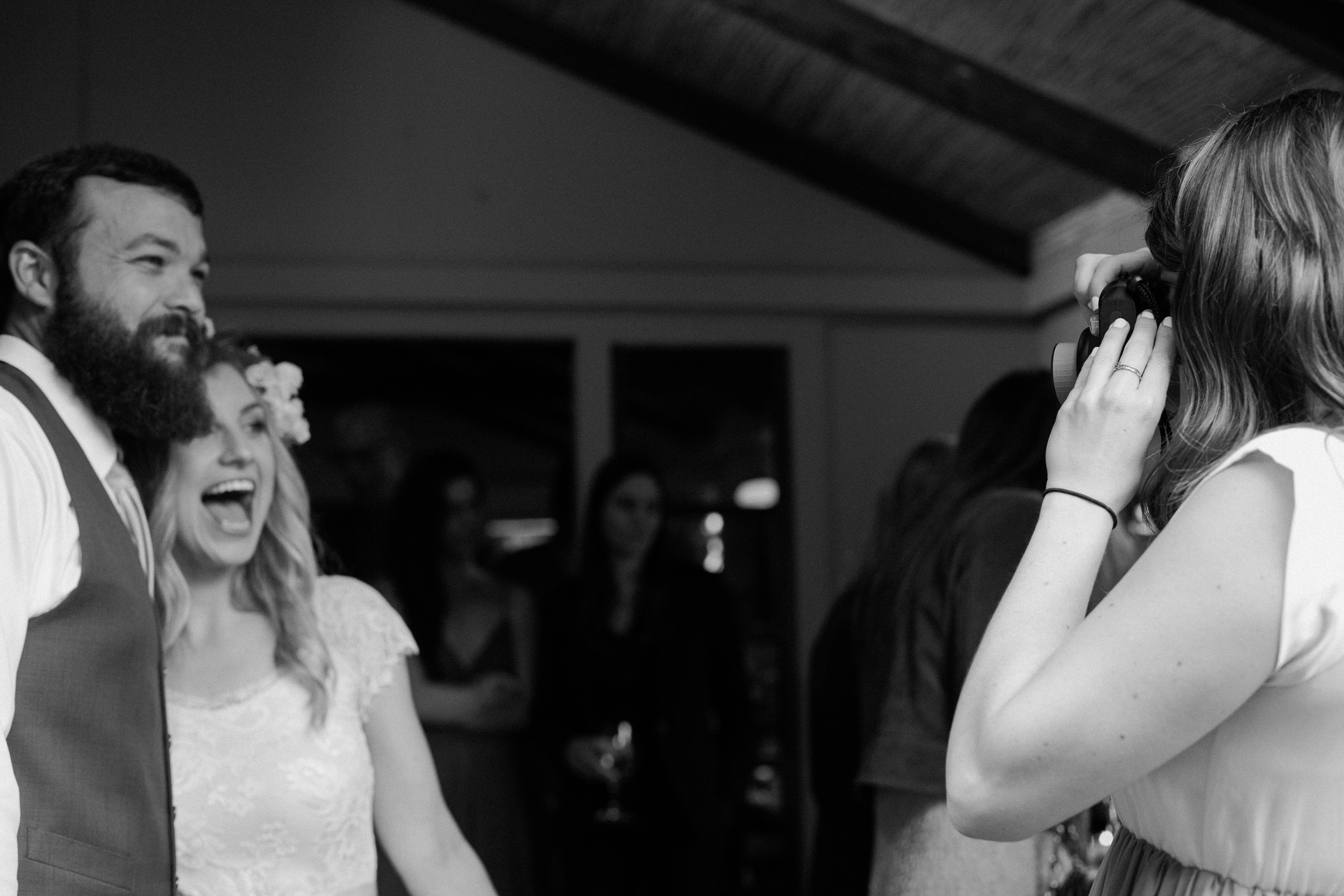 fuji acros guest takes photo of bride and groom at wedding reception in california