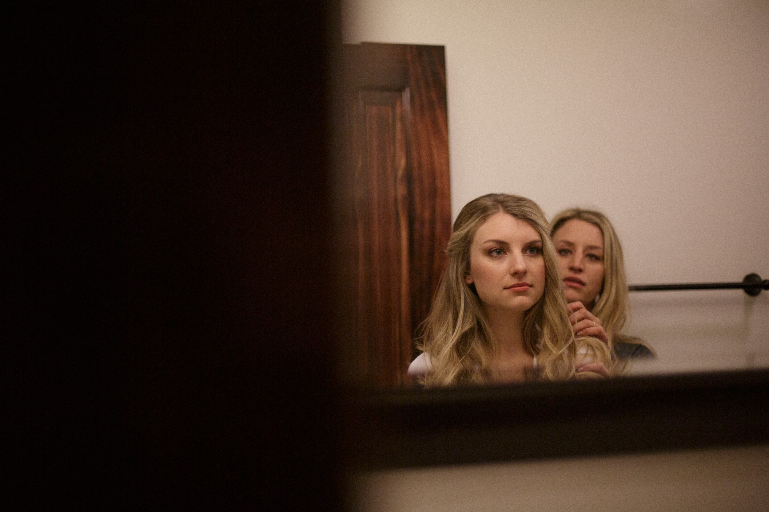 bride looks into mirror at big sur river inn documentary style moment before wedding