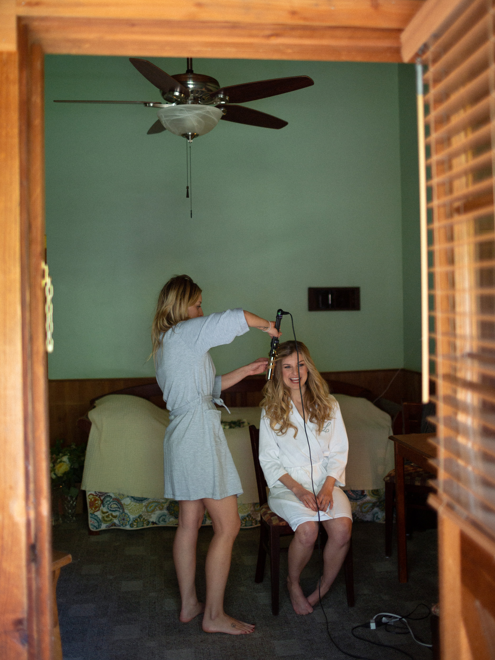 bride getting hair done looking through door into room at big sur river inn  - big sur california wedding - laid back wedding in big sur california - fuji provia film look true to life colors