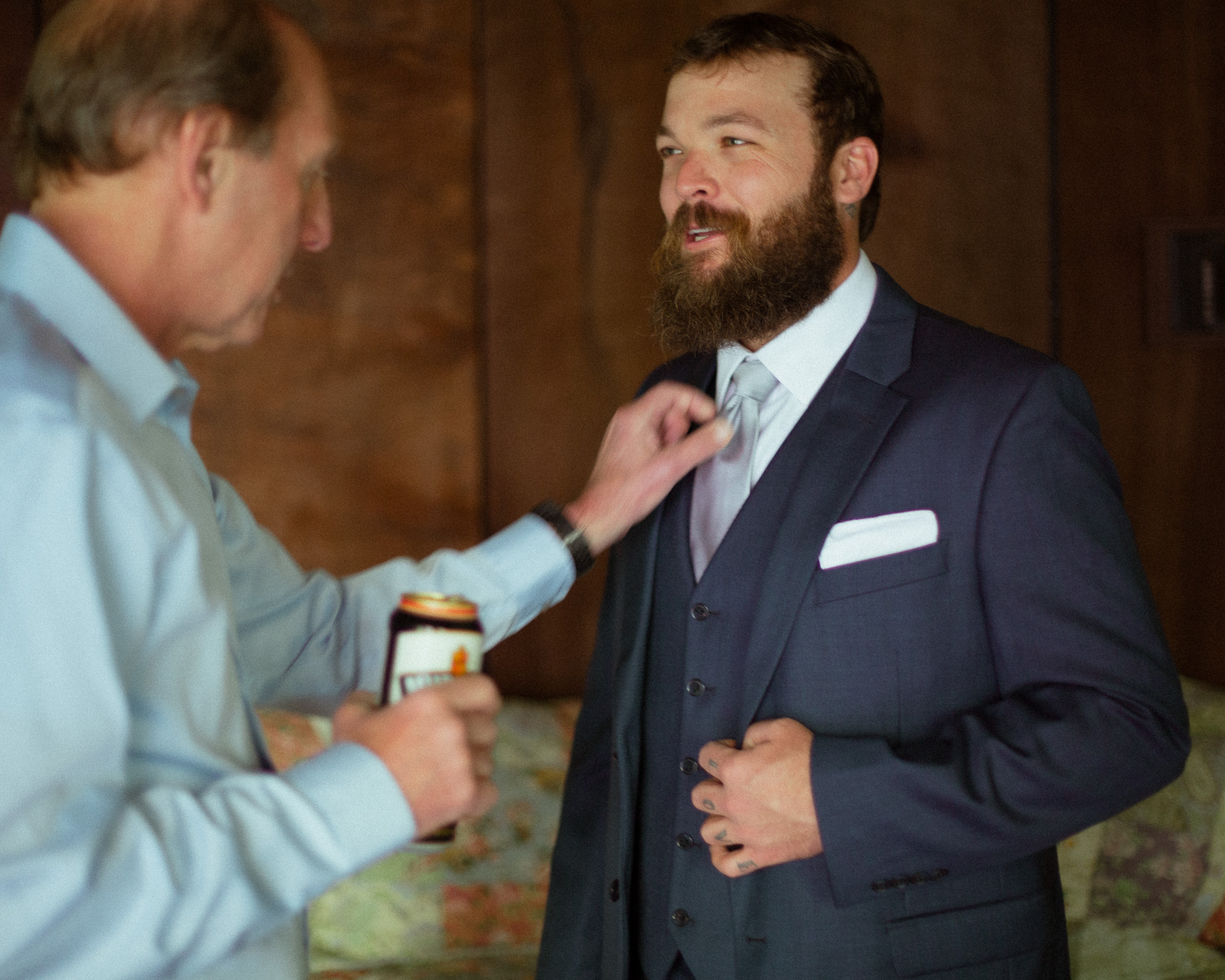 father helps groom with tie - unstaged documentary wedding photography moment