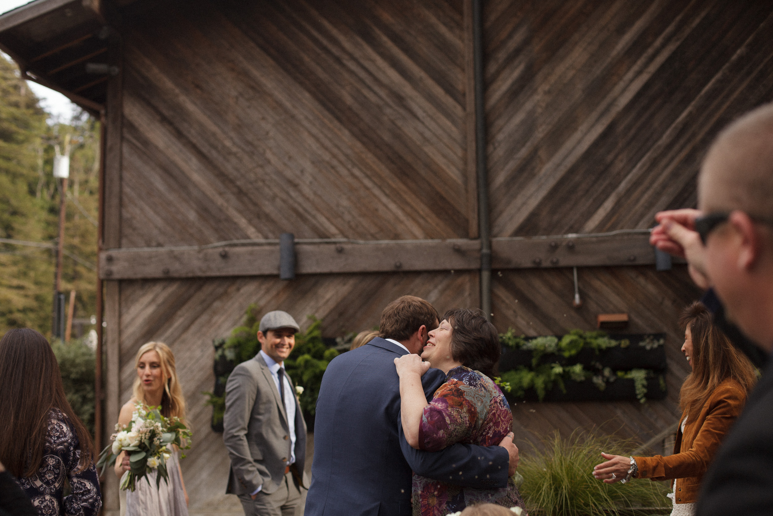 groom hugs relative after wedding ceremony at big sur river inn - big sur california wedding - laid back wedding in big sur california - fuji provia film look true to life colors