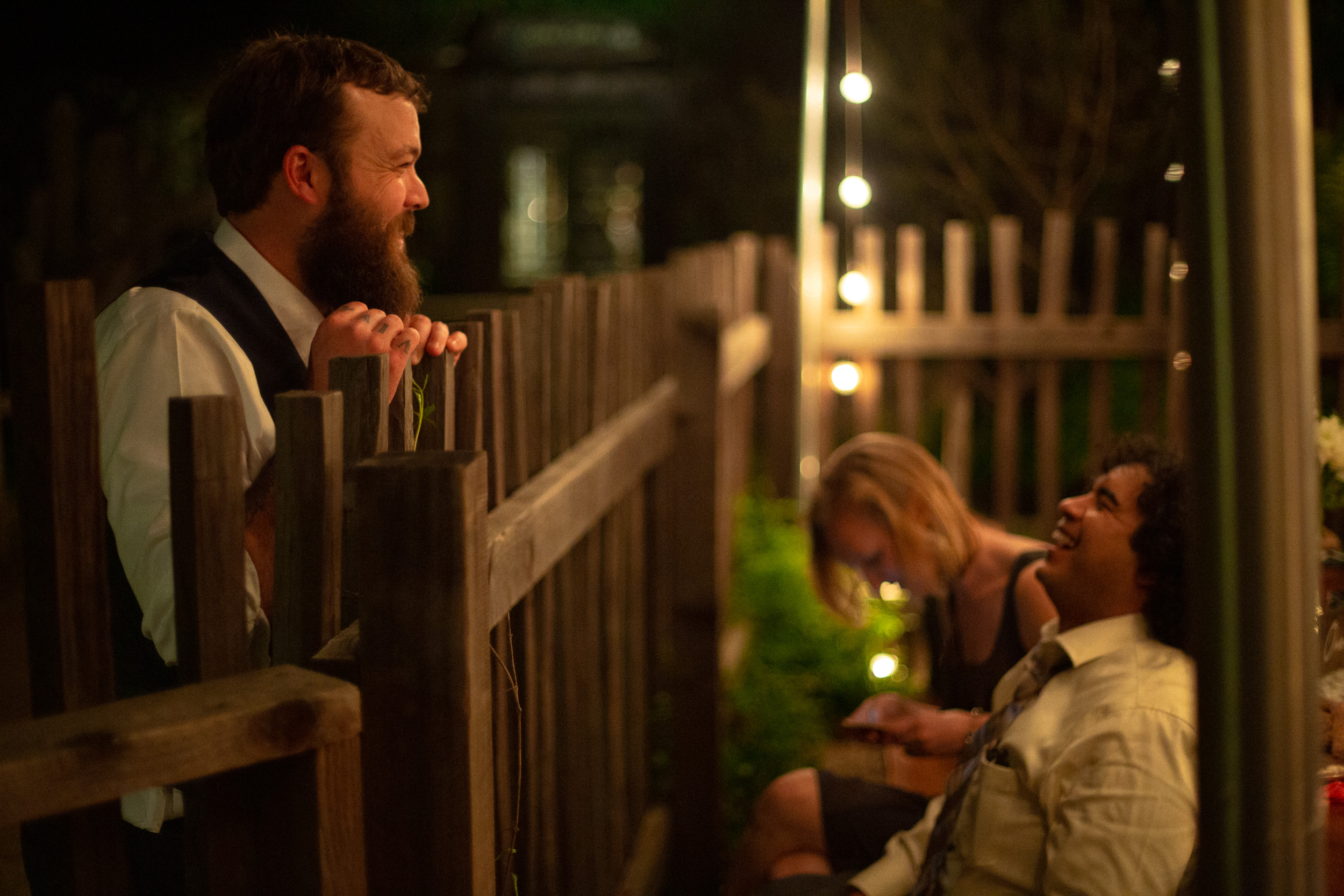 california wedding groom has a conversation with guests across fence at big sur bakery