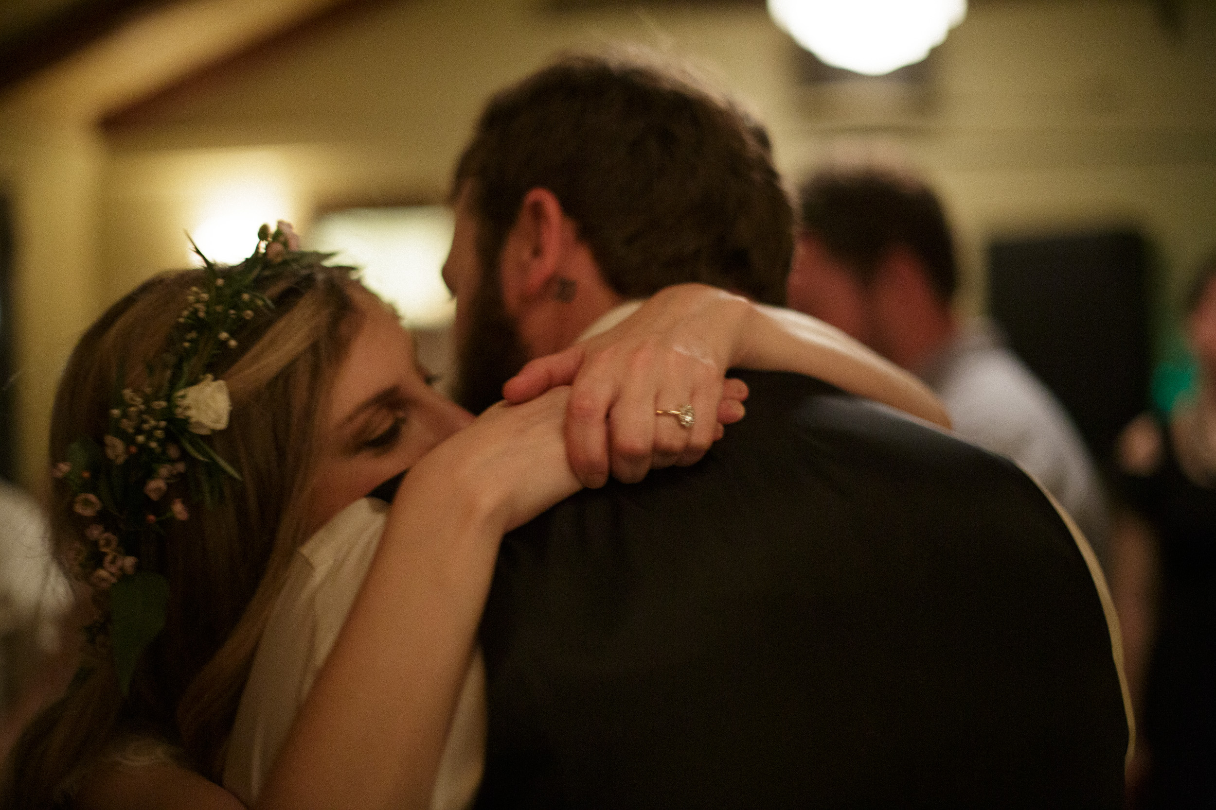 bride and groom hugging snuggling during last dance at big sur bakery wedding reception - documentary photographer film look - unintrusive photographer - realistic moments at wedding - unstaged moment at wedding