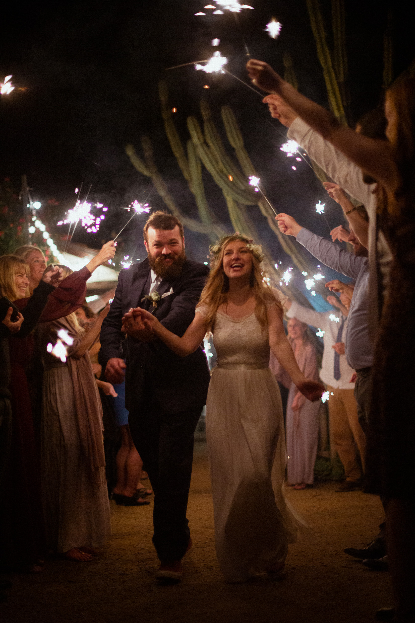 bride and groom sparkler exit from wedding reception at big sur bakery in california - in the background is a cactus