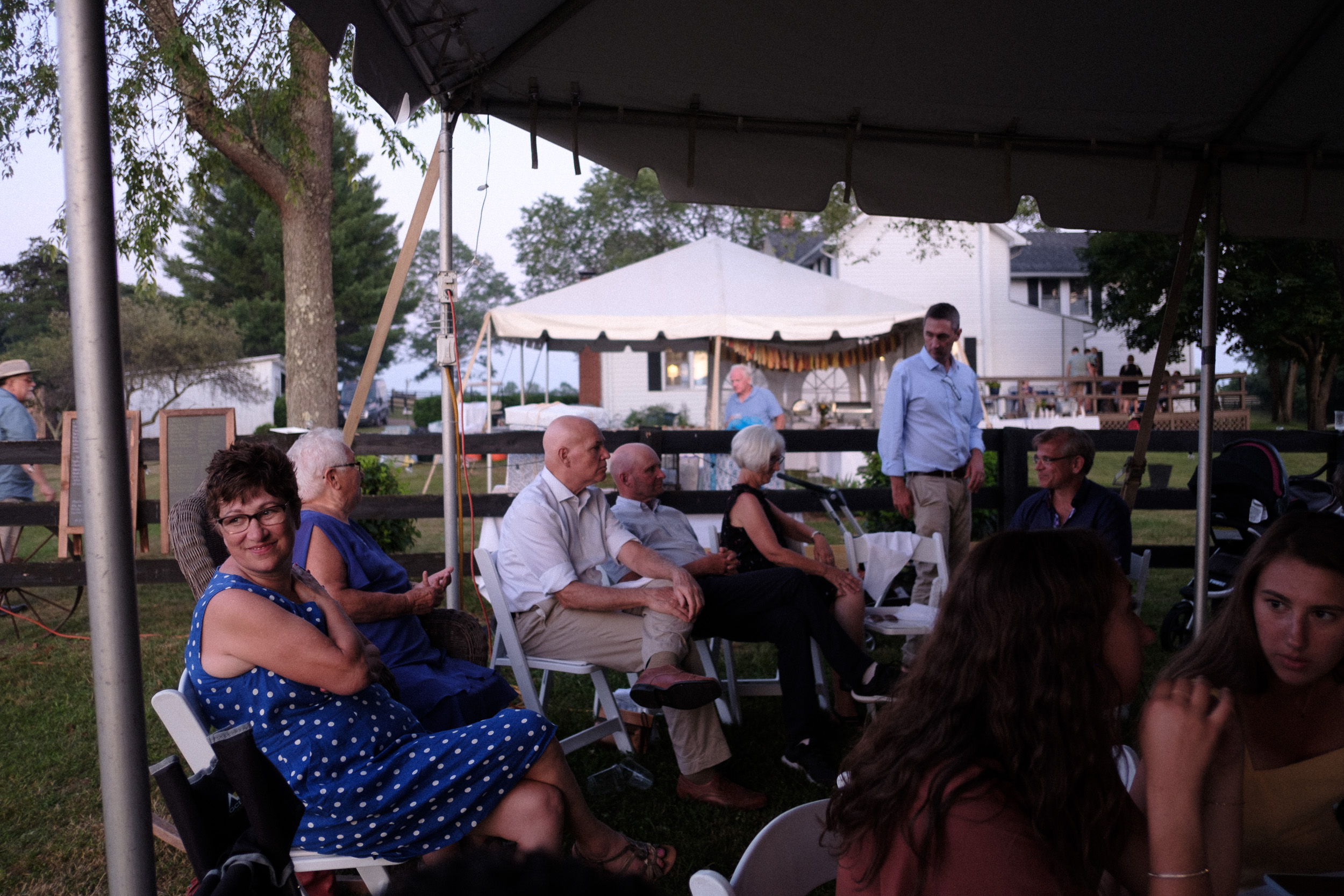 candid photography of guests relaxing at virginia backyard wedding reception - unstaged wedding photography - documentary style photography with true to life film look