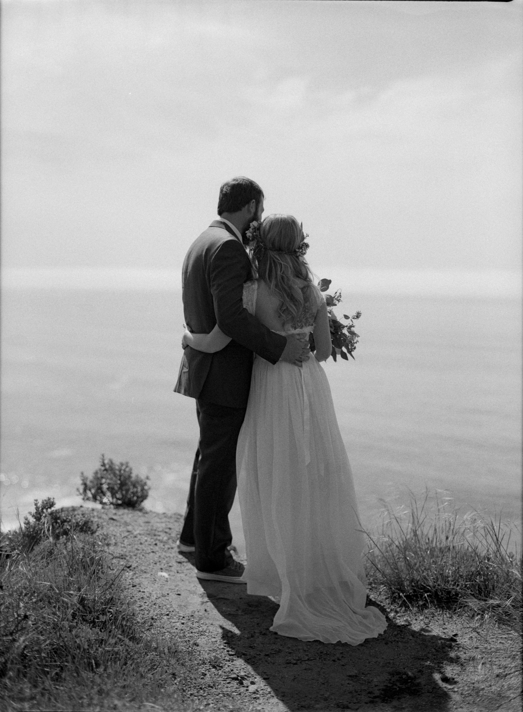 black and white film photo of wedding couple looking out over pacific ocean in big sur - big sur wedding photographer - california film wedding photographer