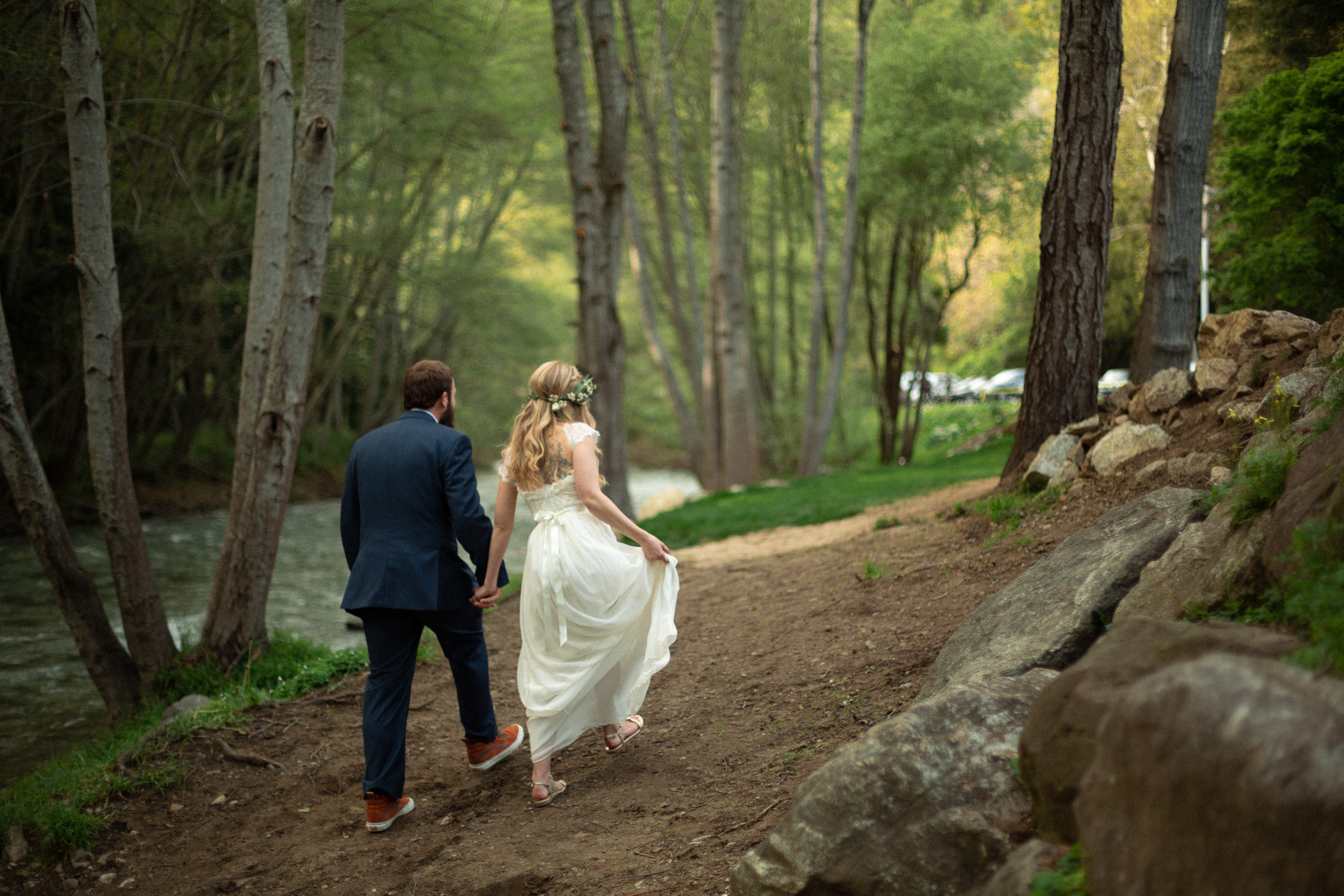 bride and groom walking away together next to big sur river  - big sur california wedding - laid back wedding in big sur california - fuji provia film look true to life colors